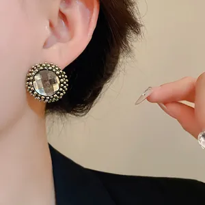Detail view of vintage palace style round flower stud earring with faceted center stone