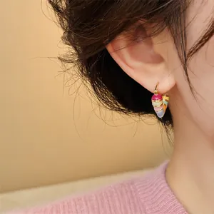 Detailed close-up showing a colorful enamel layered geometric hoop earring on an ear.