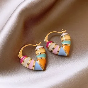 Detailed view of gold colorful heart enamel hoop earrings with vibrant striped pattern.