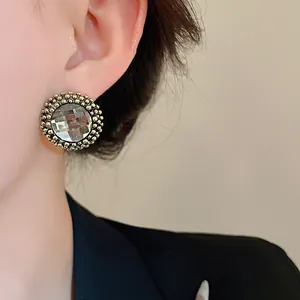 Detail of vintage court style round earring with faceted crystal and beaded border.