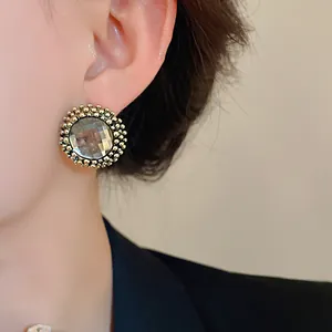 Detail view of vintage style round flower stud earrings featuring clear rhinestones.