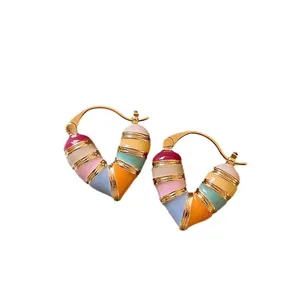 Colorful enamel heart-shaped hoop earrings with gold-tone bands for a chic fashion look.