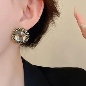 Detailed view of vintage circular flower stud earrings with sparkling center diamond
