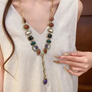 Model wearing a vintage geometric resin necklace with multicolored stones on beige dress