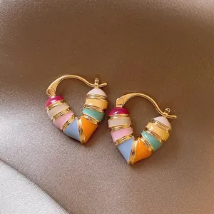 Detailed macro view of colorful heart-shaped enamel hoop earrings with gold-toned plating