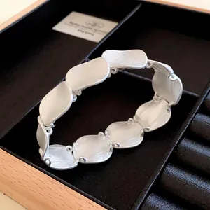 Detailansicht des minimalistischen matten silbernen Wellen-Gliederarmbands in einer Box
