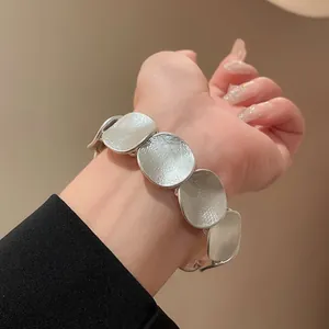Detailansicht eines silbernen minimalistischen Armbands mit strukturierten Platten