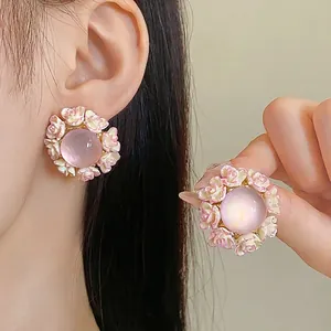 Sweet round floral resin stud earrings with silver needles shown worn by a model
