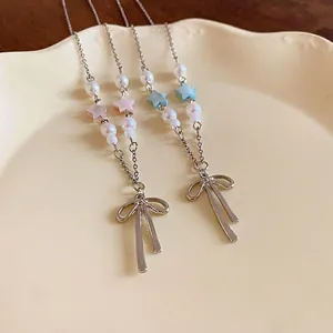 Sweet Korean style bow necklace with star and pearl pendants on a ceramic plate
