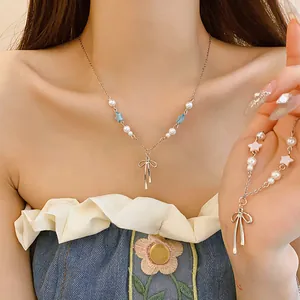 Detail view of a Korean-style star pearl necklace with a silver bow pendant on a model.