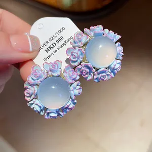Close-up detail of elegant resin rose earrings with silver needles and floral design