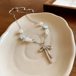 Exquisite detailed view of sweet bow pendant necklace with pearls and blue star beads