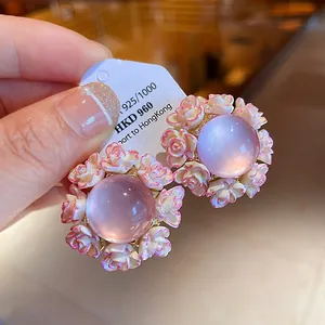 Detailed view of elegant pink resin floral stud earrings with purple center