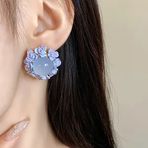 Detailed view of sweet lavender resin flower stud earrings with a light blue bead center