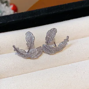 Detailed view of leaf-shaped silver earrings with sparkling cubic zirconia inlay.