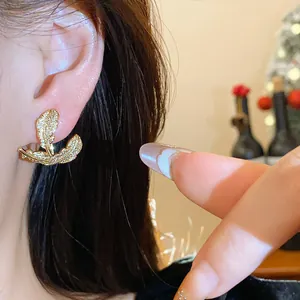 Close-up of elegant gold leaf stud earrings encrusted with sparkling zircon stones