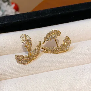 Detail view of exquisite 18k gold plated leaf stud earrings set with zircon stones