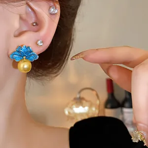 Orecchini vintage a fiore in smalto blu con una grande perla gialla e ago in argento.