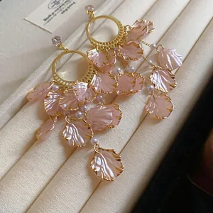 Close-up of elegant pink petal earrings with gold trim and zircon accents
