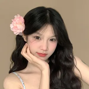 Primo piano di una dolce molletta per capelli con fiore rosa in 3D per un look estivo.