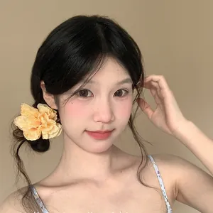 Primo piano di un fermaglio per capelli a fiori 3D indossato da una modella elegante