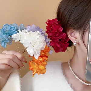 Detailed view of colorful fabric flower hairpins in blue, white, and red on a model.