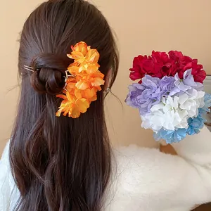Detail view of elegant fabric flower hair clips in various colors for hair styling.