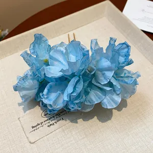 Macro view of an elegant light blue fabric flower hair pin with delicate petals