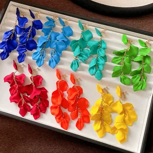 Detailed view of colorful long flower petal tassel clip-on earrings in a jewelry tray.