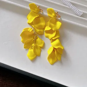 Detailed view of vibrant yellow ruffled floral petals on long tassel clip-on earrings.