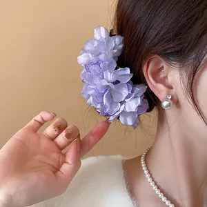 Detail of purple floral hair fork showing delicate fabric petals on an elegant updo
