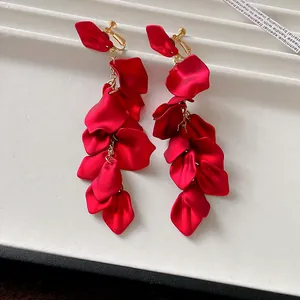 Detail shot of elegant red rose petal tassel clip-on earrings with gold chains