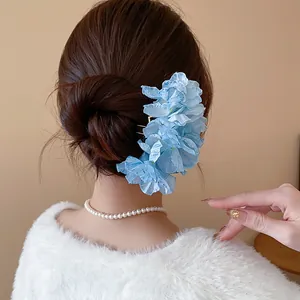 Close-up view of an elegant light blue fabric flower hair fork styled in a classic bun