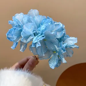 Detailed macro view of a light blue fabric flower hair fork featuring soft petal textures.