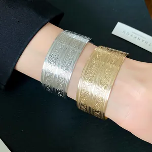Detailansicht von silbernen und goldenen gravierten Metall-Armreifen im Vintage-Stil
