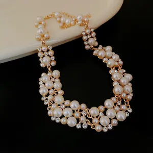 Primo piano di un'elegante collana di perle con dettagli in strass su uno sfondo nero