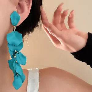 Detailed macro view of teal matte flower petal tassel long earrings worn by model