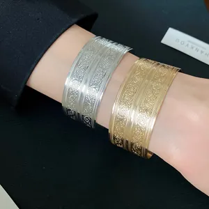 Nahaufnahme von gravierten Vintage-Metallarmreifen in elegantem Gold- und Silberfinish