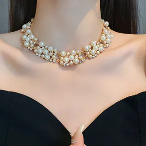 Dettaglio di un'elegante collana girocollo in perle e strass con design a grappolo