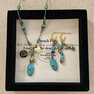 Dettaglio di collana e orecchini bohémien con perline di turchese in scatola vintage