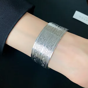 Detaillierte Nahaufnahme eines gravierten Metallarmreifs mit elegantem Blumenmuster