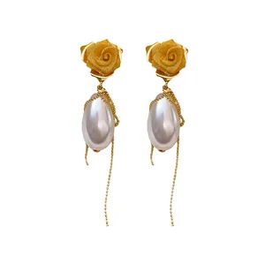 Eleganti orecchini a rosa con perla a goccia e lunghe nappe a catena dorata lucida