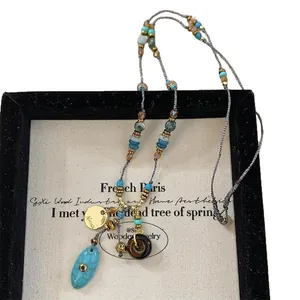 Collana di perline in stile bohémien etnico con ciondoli turchesi su display vintage