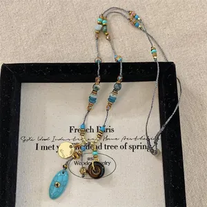 Dettaglio ravvicinato della collana boho con perline di turchese e pietre naturali