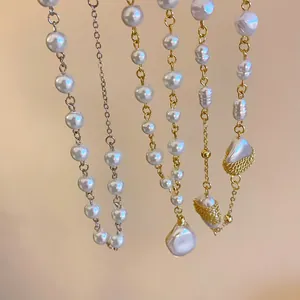Detail view of various pearl necklaces with gold and silver chains for elegant layering.