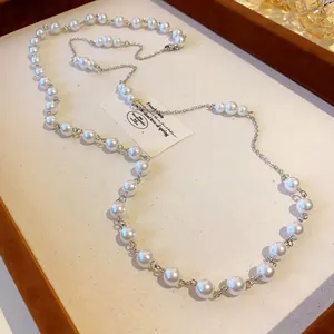 Macro detail of French style pearl necklace with silver links on a white display.