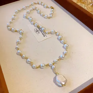 Detail shot of a French light luxury pearl necklace with an irregular baroque pearl pendant.