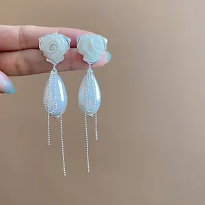 Dettaglio orecchini con rosa in rete, goccia di perla ed eleganti nappine di perline