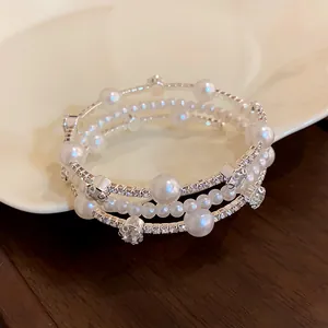Close-up detail of a multi-layer wrap bracelet with pearls and rhinestones.