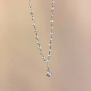 Elegant French style necklace featuring a unique irregular pearl pendant on gold chain